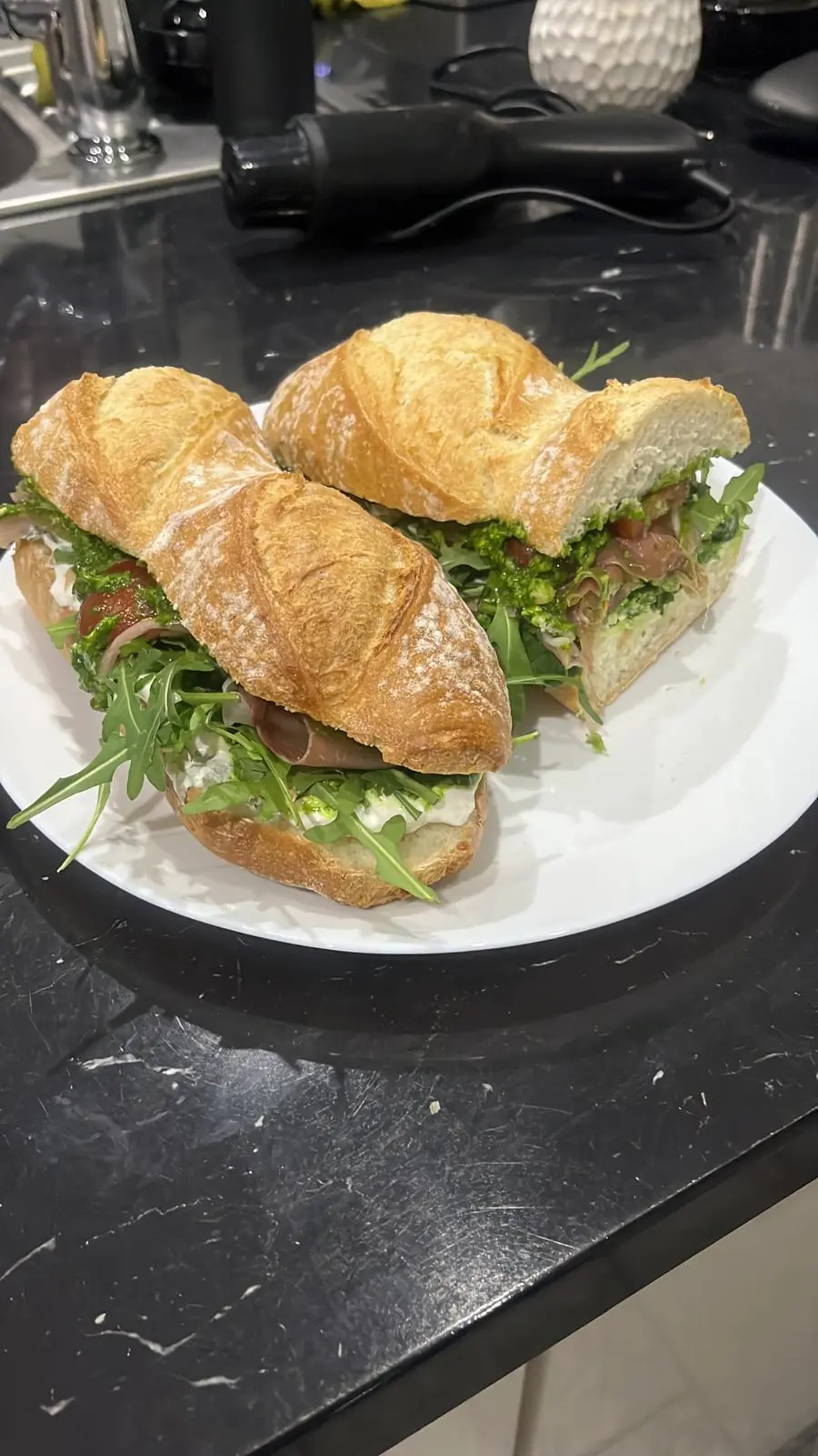 Zdjęcie źródłowe – ciabatta z burratą, pomidorkami, rukolą, prosciutto i pesto szpinakowym